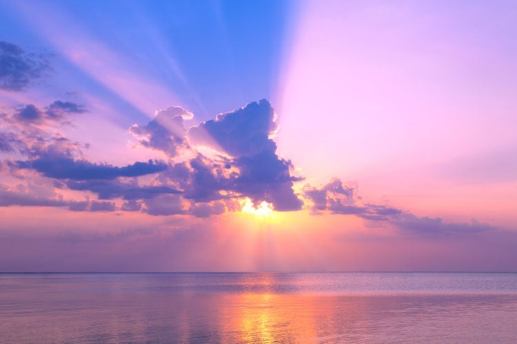 Sun behind pink clouds and above sea Sun behind pink clouds and above sea